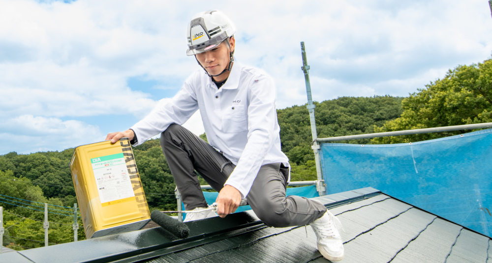 ローラーで屋根を塗装している様子
